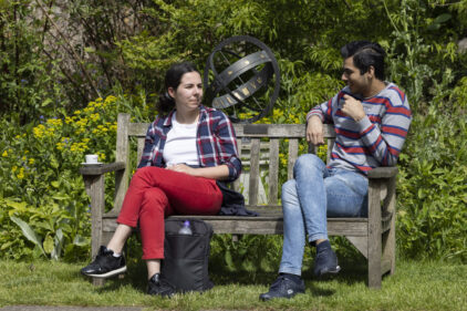Two students talking on a bench